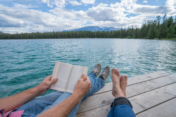 年轻情侣在湖边码头上放松图片下载