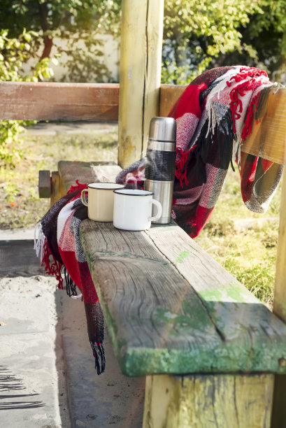 木桌上放着热茶的保温瓶。图片下载