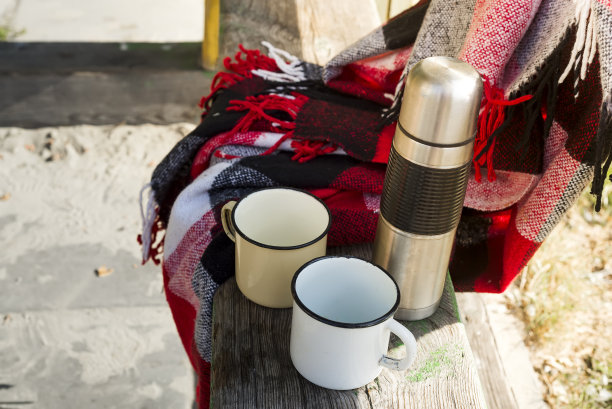 木桌上放着热茶的保温瓶。图片下载