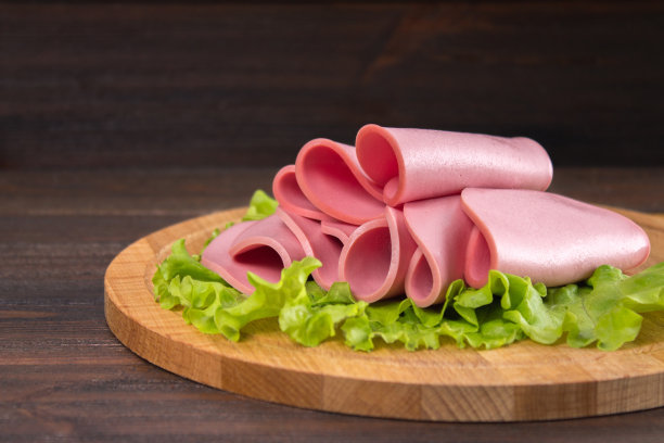 木质背景上的沙拉叶切片香肠图片下载