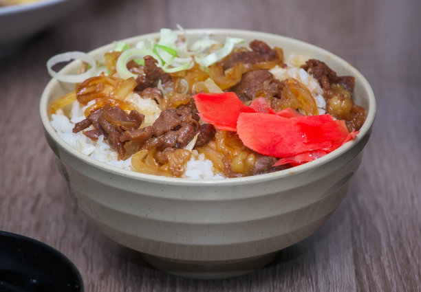 九段传统的日本食物。把洋葱肉片放在米饭上。碗牛肉图片下载