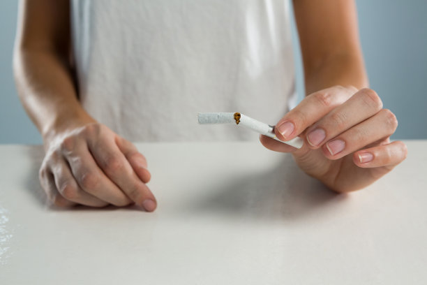 在白色背景下抽着香烟的女人图片下载