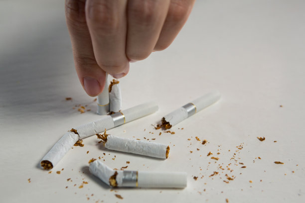 在白色背景下，女人用手掰开香烟图片下载