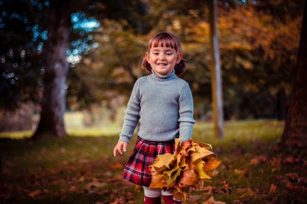 小女孩在玩树叶和烛台图片下载