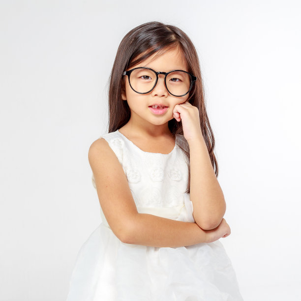 可爱的亚洲小女孩的肖像在白色的背景站和摆姿势的白色连衣裙图片下载