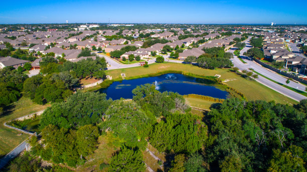 绿树和池塘与喷泉圆石，德克萨斯州，美国无人机俯瞰郊区社区与大量的家庭图片下载