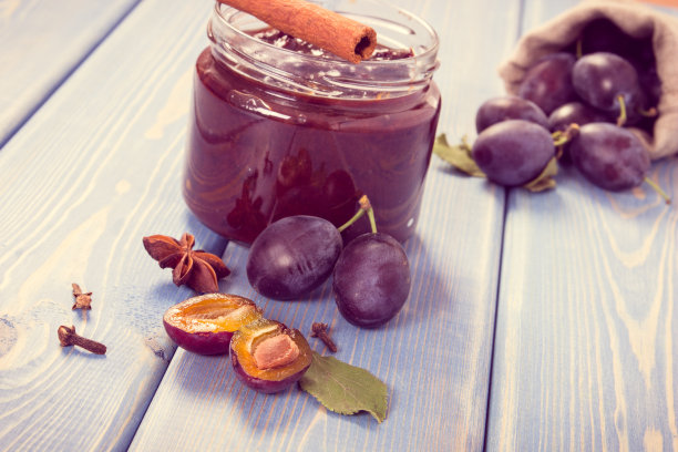 复古照片，罐装新鲜李子果酱，板上放成熟的水果和香料，健康的甜品图片下载