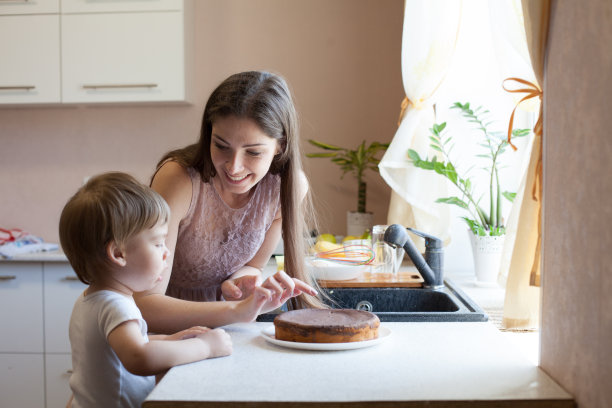 母亲和儿子在厨房吃馅饼图片下载