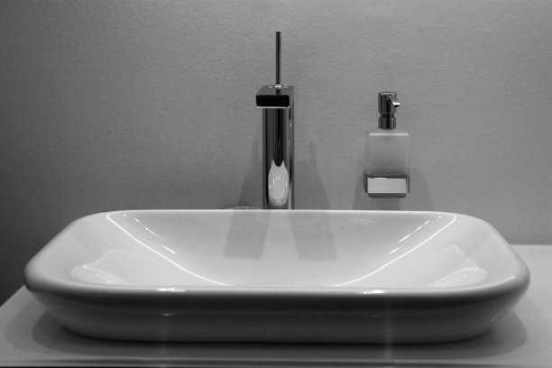 白色墙壁上的陶瓷面盆和肥皂喷雾器图片下载