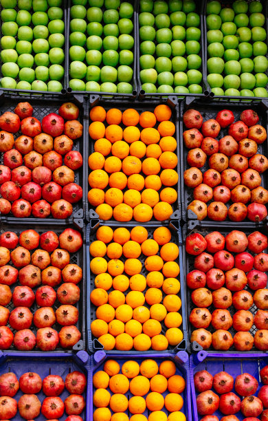 市场上有成箱的橘子，苹果，石榴图片下载