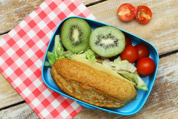 健康的学校午餐盒，包括棕色芝士三明治，樱桃番茄和猕猴桃图片下载