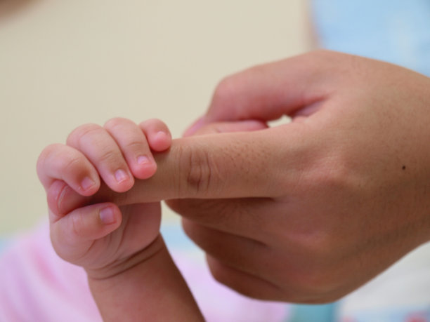 婴儿的手抓住了她妈妈的手指图片下载