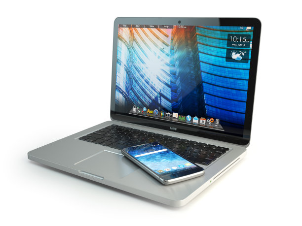 手机上的笔记本电脑键盘上隔离白色。通信的概念。图片下载