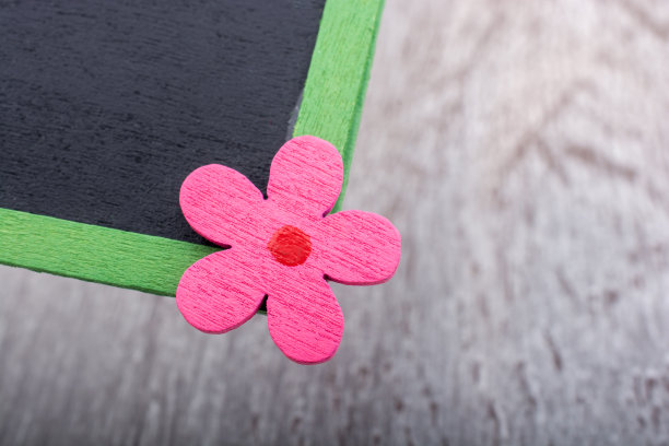 在绿色草地上放置有花卉图标的黑板图片下载