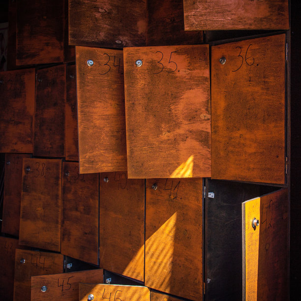 一个废弃的旧邮局里的信箱，上面有手写的号码和储物柜，一排排排列着，有的开着，有的关着图片下载