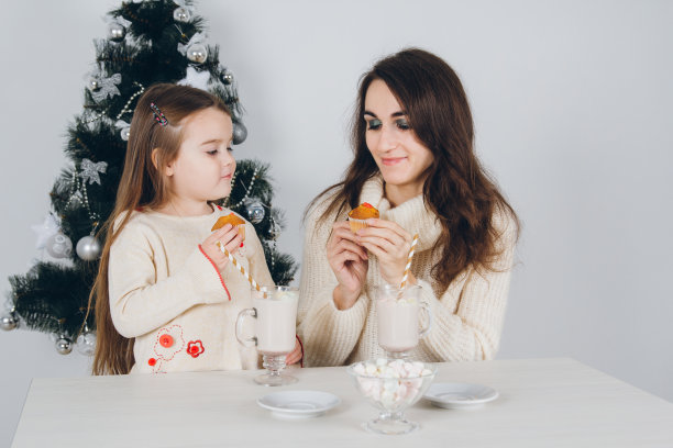 妈妈和小女儿吃着美味的纸杯蛋糕图片下载