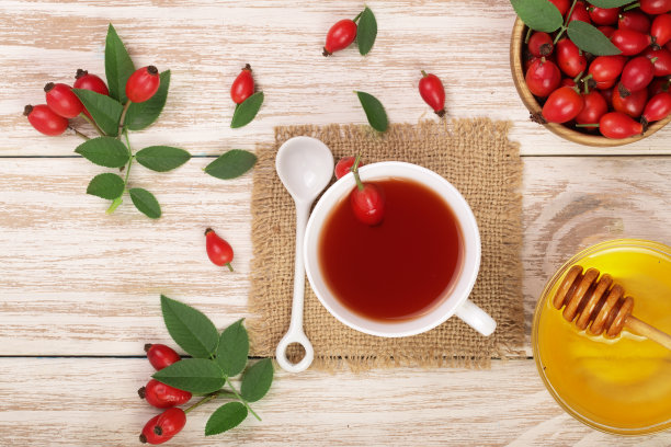 白木背景上的玫瑰果蜂蜜茶（顶视图）图片下载