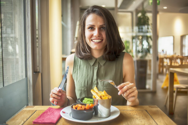 年轻女子在餐馆吃午饭图片下载