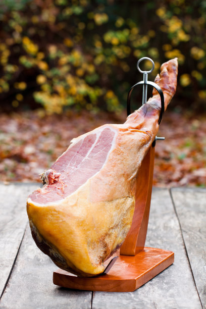 整个火腿放在木桌上的木架上图片下载