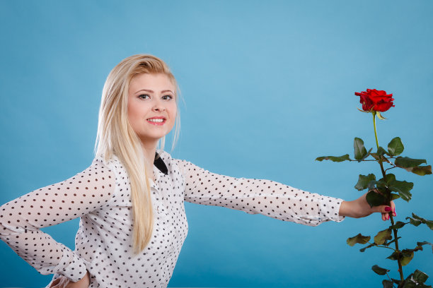 女人拿着红玫瑰花在蓝色图片下载