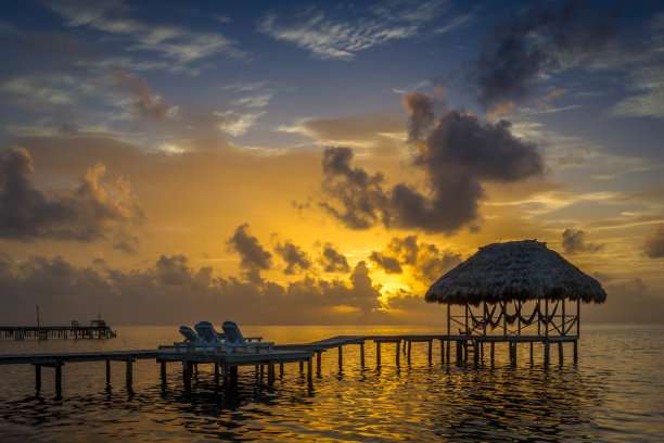 码头与小屋俯瞰美丽的加勒比海日出科克尔岛，伯利兹图片下载