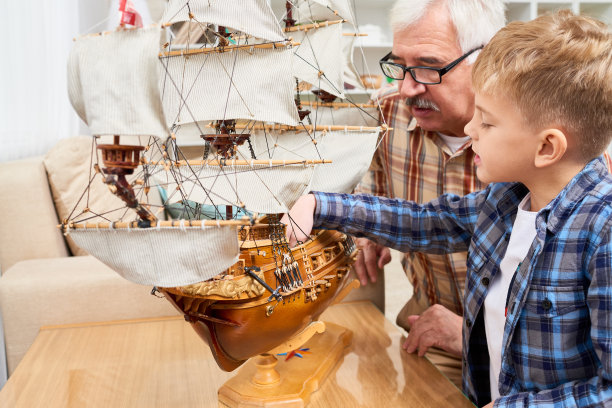 好奇的男孩看模型的船图片下载