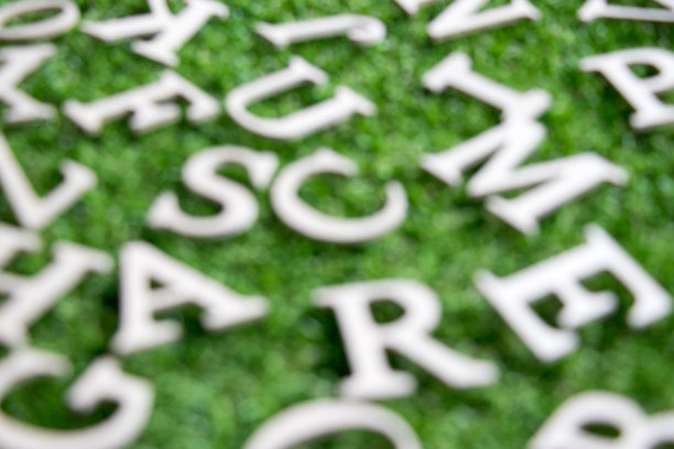 模糊的英文字母在人工绿草的背景图片下载