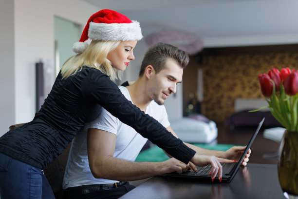 年轻的白人夫妇在家里用笔记本电脑网购圣诞礼物图片下载