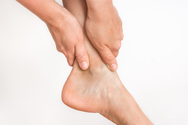 一个脚踝疼痛的女人抱着她疼痛的腿图片下载