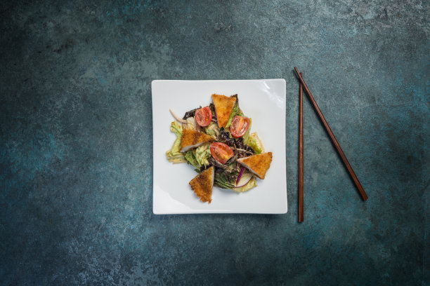 泛亚沙拉，蔬菜配炸鸡。用筷子夹在方形的白色盘子上。俯视图图片下载