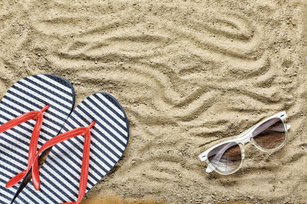 海滩的背景。沙滩拖鞋和太阳镜图片下载