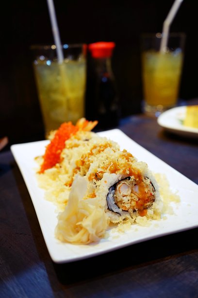 脆脆的面包卷，配上木色背景的白色盘子上的天妇罗虾图片下载