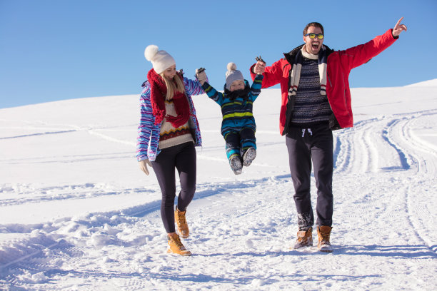 有吸引力的家庭在一个冬季公园在山上玩素材图片