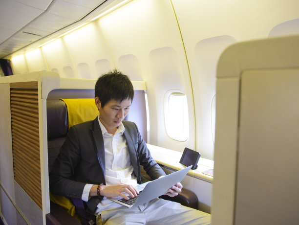 亚洲商人在头等舱使用笔记本电脑图片下载
