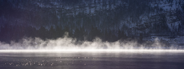山湖上的晨雾和岸边的积雪。冬天的风景。图片下载