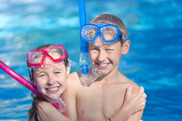 十几岁的兄弟姐妹戴着泳镜在游泳池里家庭度假图片下载