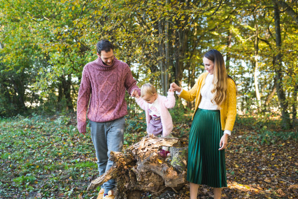小女孩和她的父母爬在树枝上图片下载