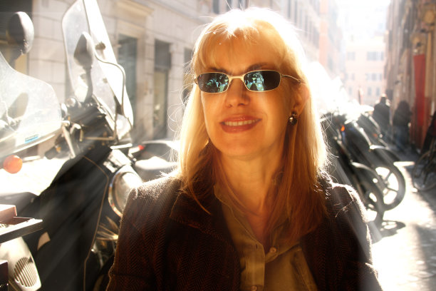 意大利，罗马:戴着墨镜的金发游客，摩托车，建筑物图片下载