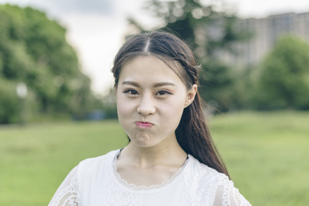 年轻女子噘起嘴唇，特写镜头。素材图片
