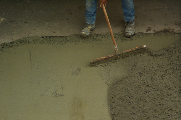 工人使用大的修整抹刀工具来光滑和平整小的住宅板图片下载