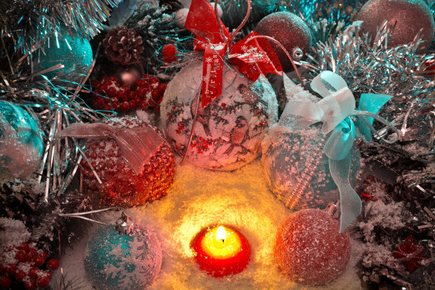 圣诞蜡烛在雪中围绕着圣诞玩具和球图片下载