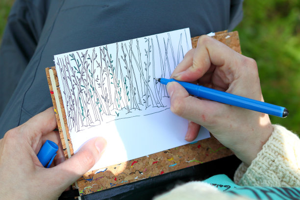 女孩的手画一个抽象的幻想素描卡与树木和草的涂鸦风格图片下载