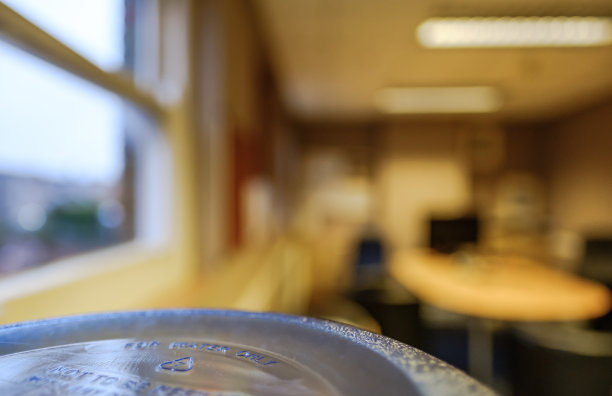 特写，浅焦点的大，塑料饮水机的顶部看到一个大，开放式办公室，mer到一个窗框。图片下载