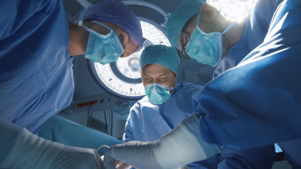 进行手术的医生团队的低角度视图。病人的观点。素材图片
