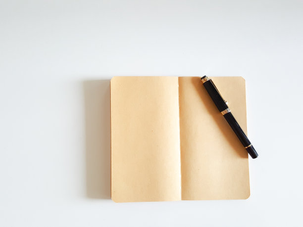 俯视图打开笔记本和钢笔在白色书桌的背景。图片下载