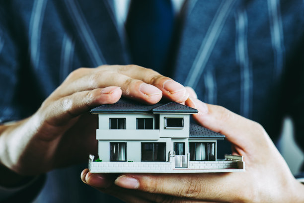商人的手拿着房子模型素材图片