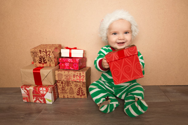 圣诞婴儿在圣诞帽拿礼物盒图片下载