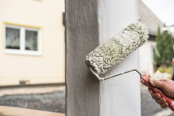 房屋修缮专业油漆工正在用漆辊漆柱外部图片下载