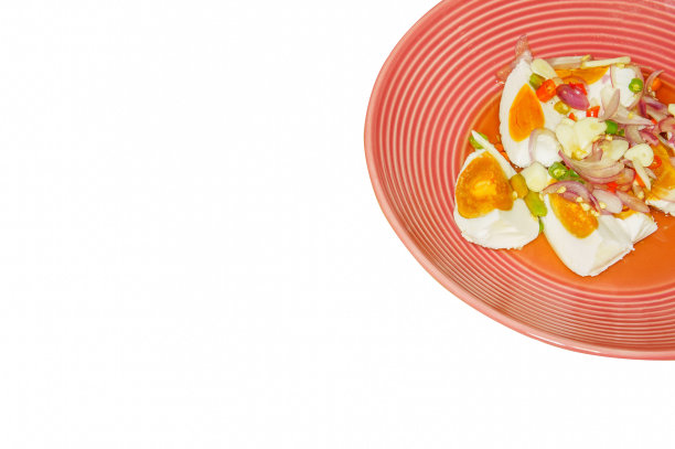 泰国菜:辛辣的鸡蛋沙拉，配上葱，大蒜和辣椒，放在粉红色的盘子里。它孤立了白色背景。图片下载