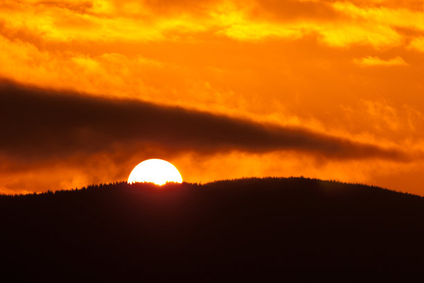 红色日落与戏剧性的云和山脊剪影图片下载